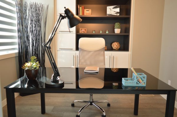 Un bureau noir aménagé avec un fauteuil blanc