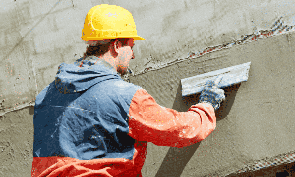 artisan travaillant sur un mur extérieur